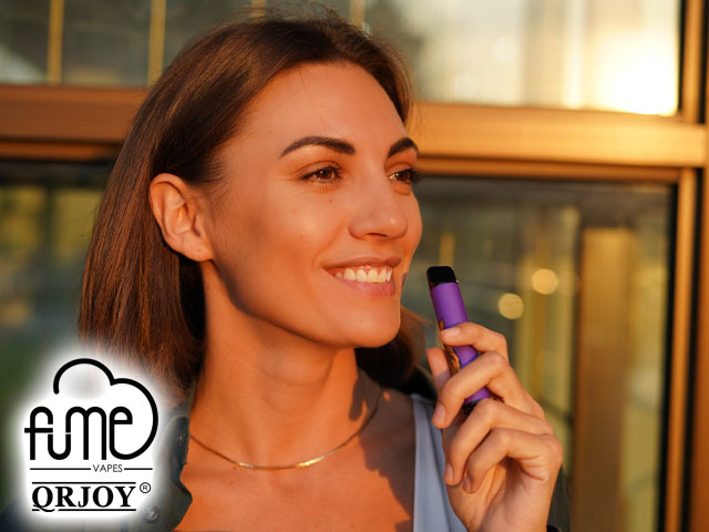 woman smiling enjoying disposable vape nicotine strength